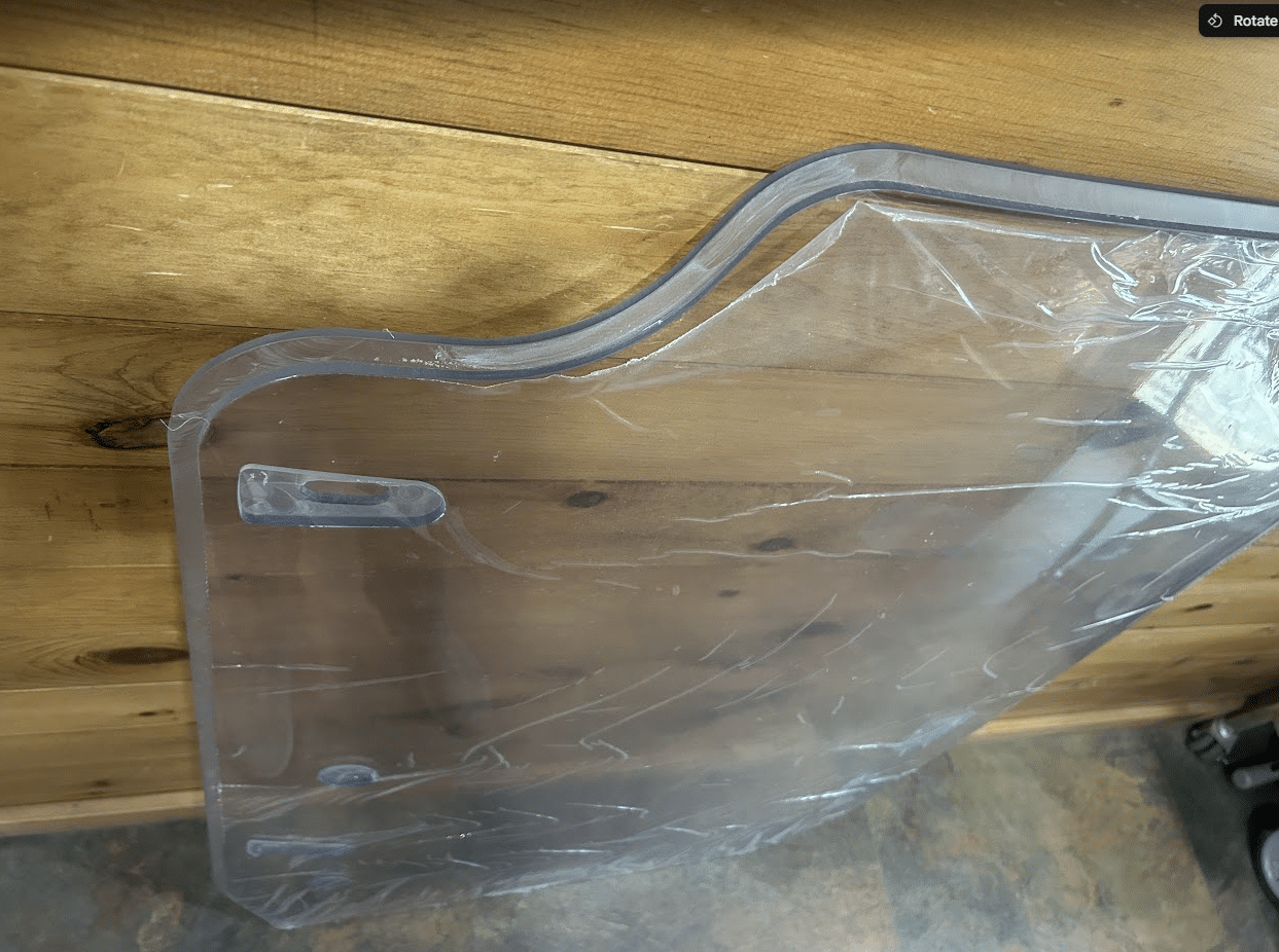 Corner edge detail of the Case DL550 TV620B Minotaur polycarbonate windshield showing the rubber seal and frame profile
