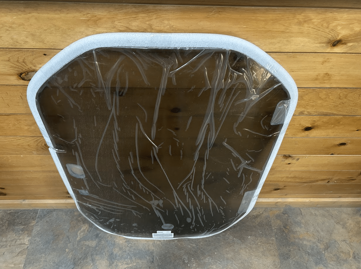 Rear view of a Wacker Neuson ST/SW tinted polycarbonate windshield showing the white rubber frame and back surface