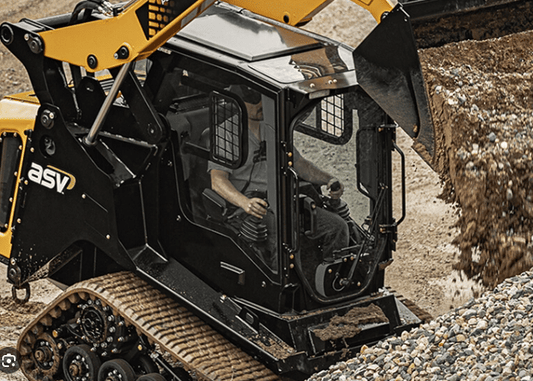 ASV Max-Series compact track loader working at a construction site, showing the enclosed cab with polycarbonate windshield installed