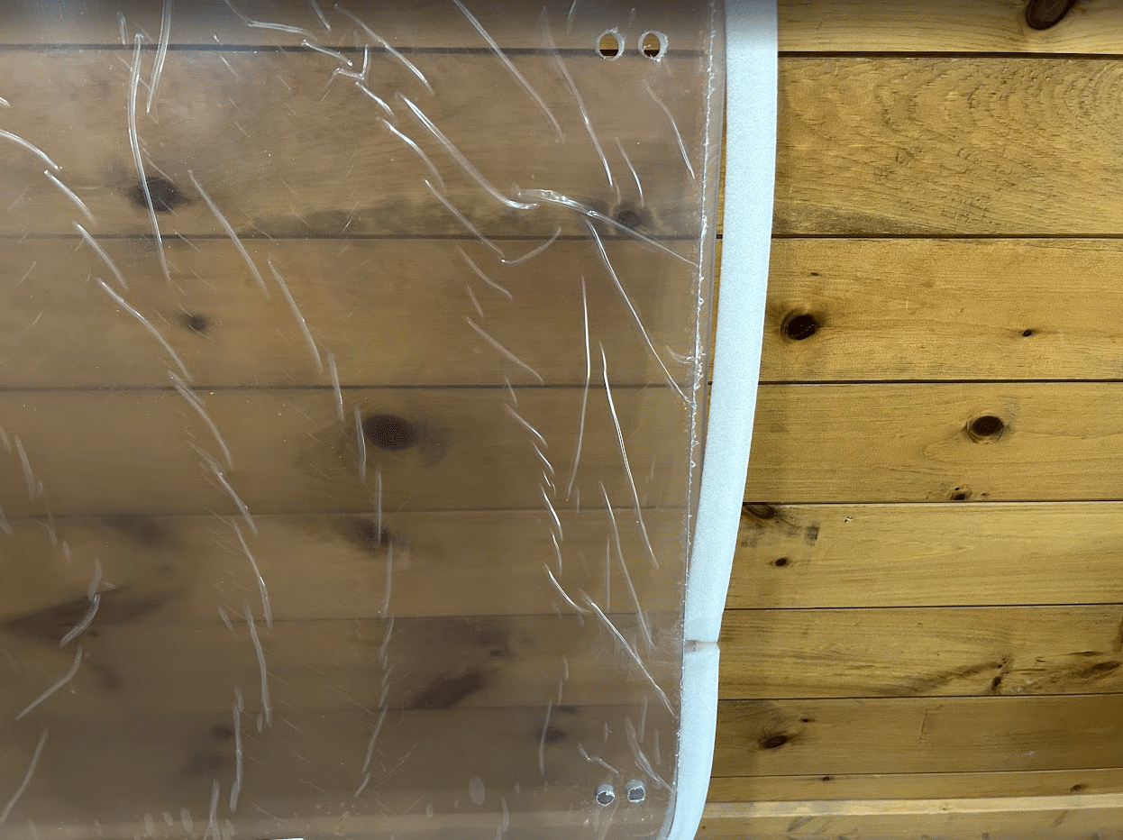 Top edge detail of ASV Max-Series polycarbonate windshield showing foam edge seal strip and upper mounting hole positions