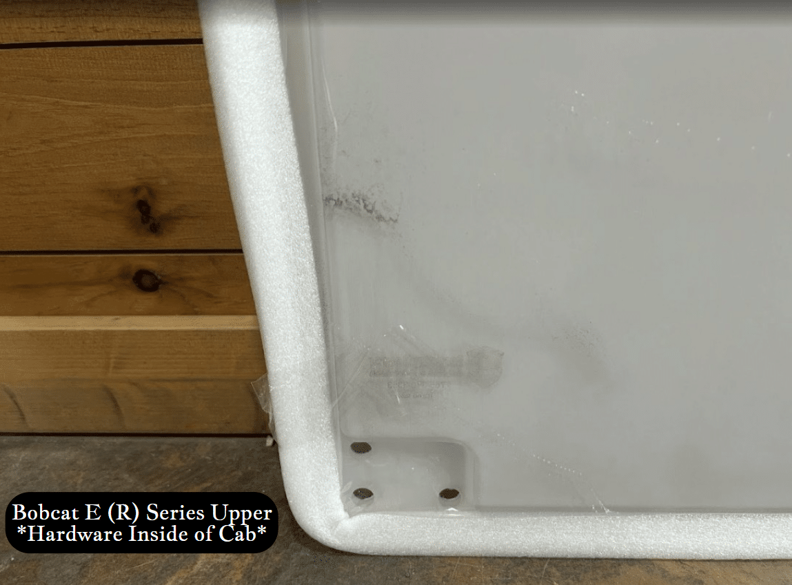Bottom corner detail of Bobcat E (R) Series upper windshield showing interior bracket with mounting holes and foam seal edge