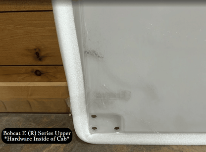 Bottom corner detail of Bobcat E (R) Series upper windshield showing interior bracket with mounting holes and foam seal edge