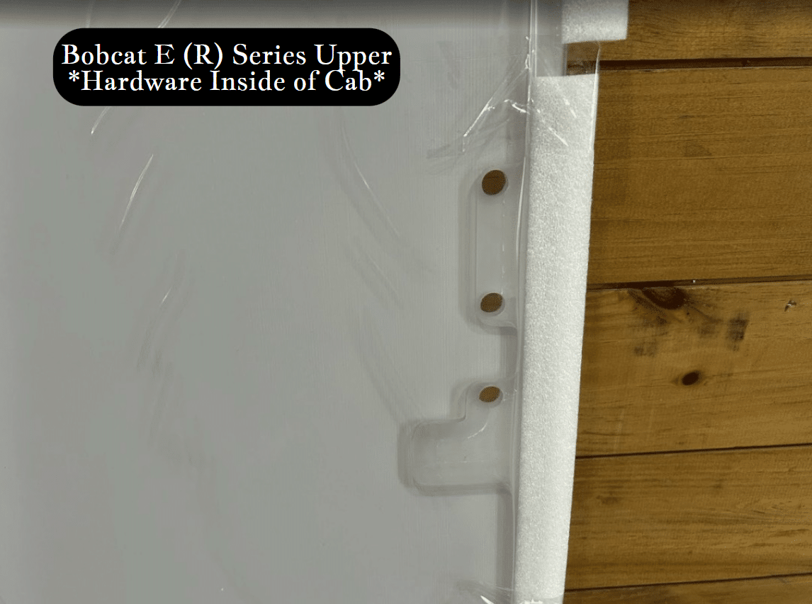 Close-up detail of Bobcat E (R) Series upper windshield edge showing foam seal and mounting stud hardware on the side