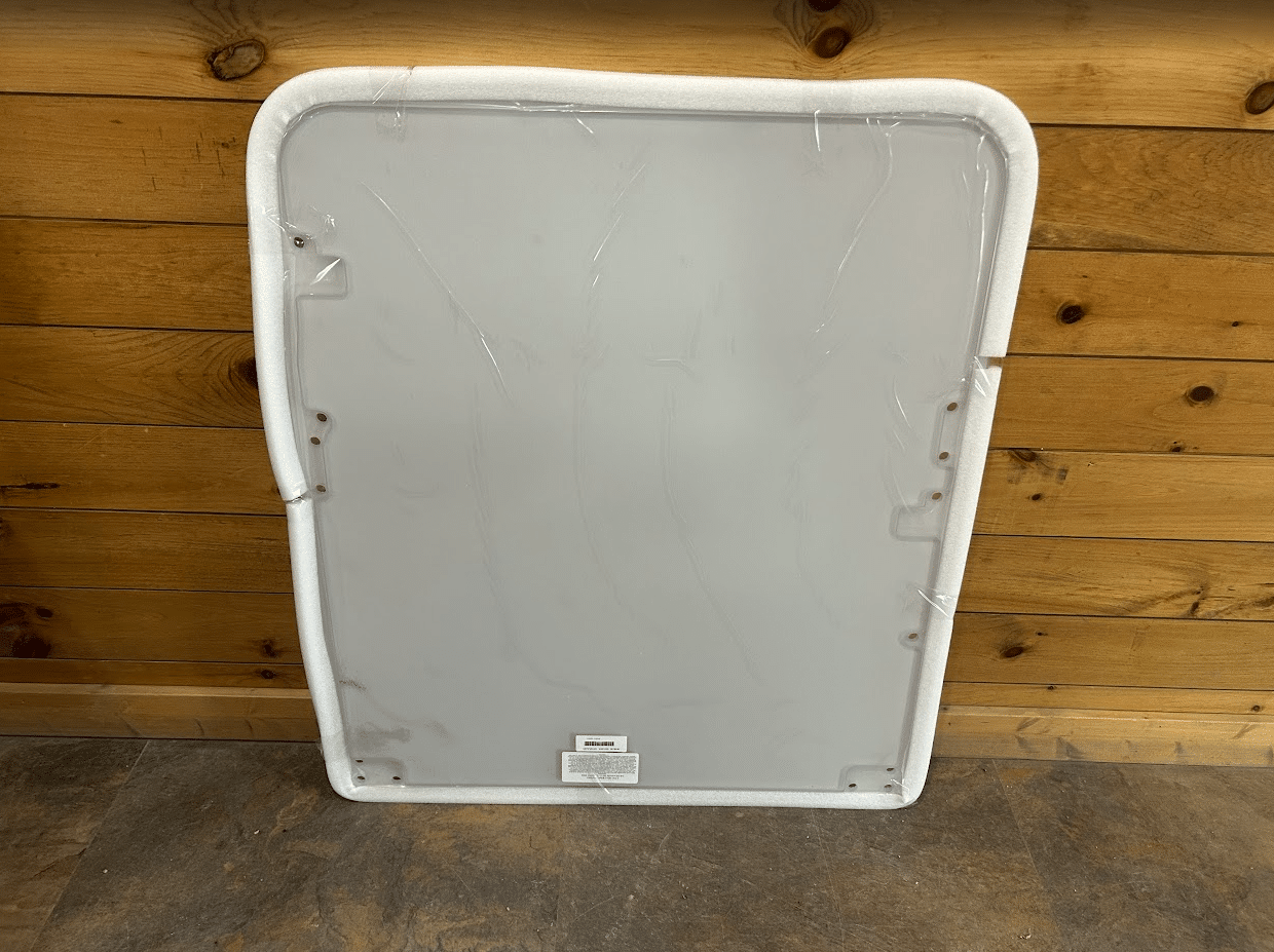 Bobcat E Series excavator polycarbonate windshield replacement with white foam perimeter seal, front view against wooden wall