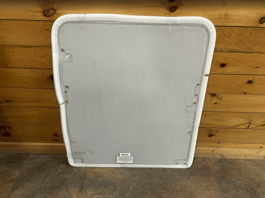 Bobcat E Series excavator polycarbonate windshield replacement with white foam perimeter seal, front view against wooden wall