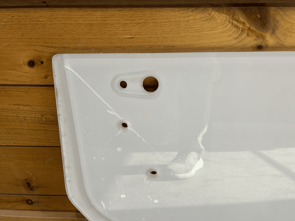 Close-up of Bobcat E Series lower excavator windshield top edge showing pre-drilled mounting holes for installation
