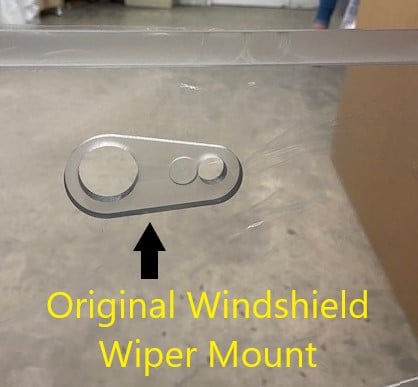 Close-up of original Bobcat G Series OEM windshield showing the wiper mount location, annotated with yellow text overlay