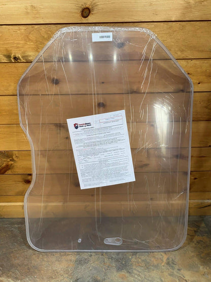 Bobcat G Series clear polycarbonate windshield replacement in protective wrap with installation instruction sheet, leaning against wood wall
