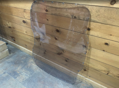 Bobcat M Series 3/4 laminated polycarbonate forestry windshield showing full shape with curved side cutouts and mounting hardware