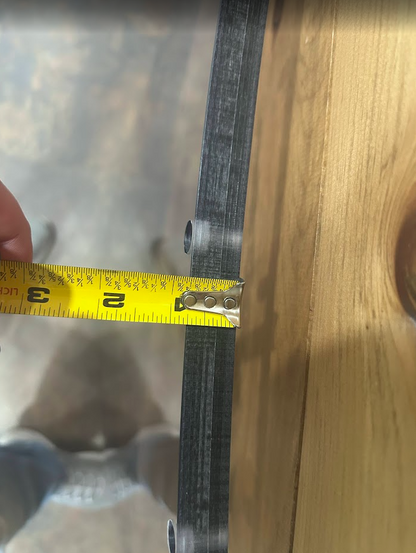 Close-up of Bobcat M Series forestry windshield edge with measuring tape showing 3/4 inch laminated polycarbonate thickness