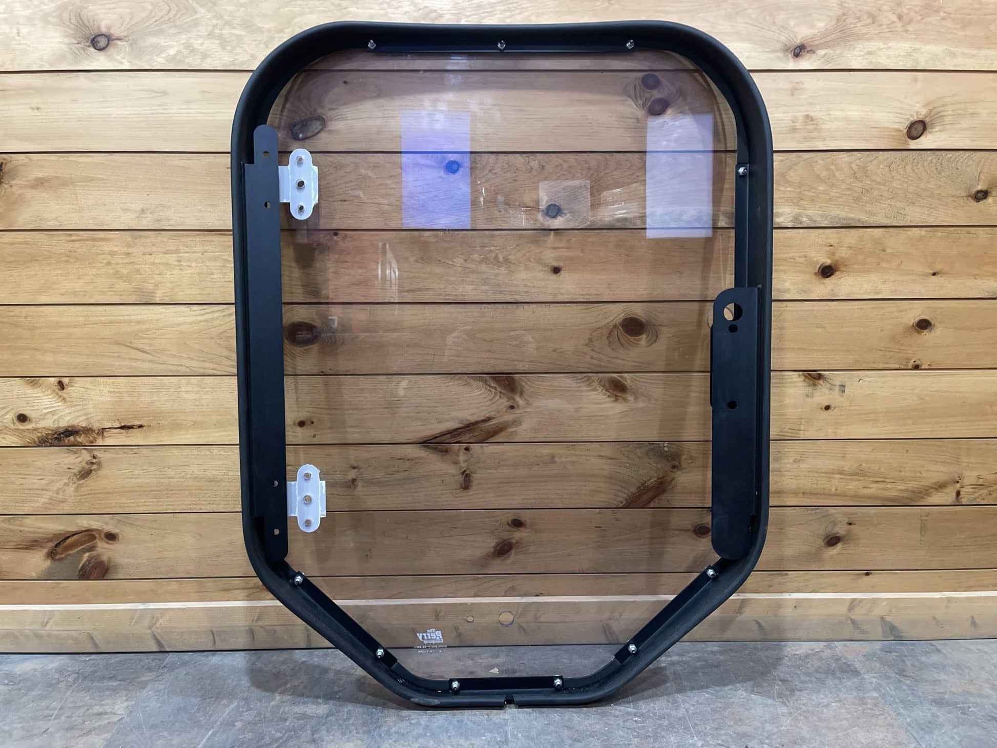 Bobcat M Series steel frame and polycarbonate windshield replacement, machine-side rear view showing inner frame and hinge brackets