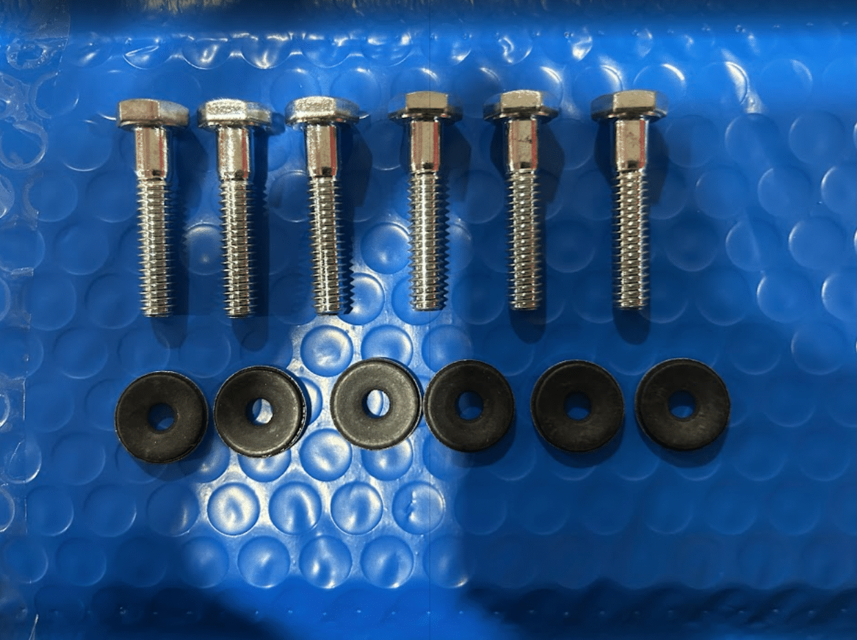 Bobcat M Series side window mounting hardware kit showing 6 hex bolts and 6 rubber washers on bubble wrap