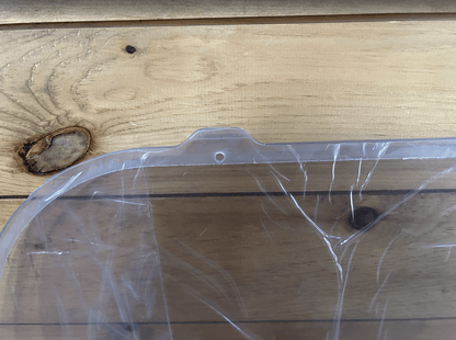 Close-up of Bobcat M Series polycarbonate side window top edge showing rubber seal channel and mounting post
