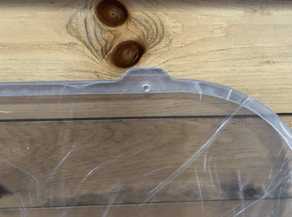 Close-up of Bobcat M Series polycarbonate side window upper corner showing rubber seal gasket channel and curved edge