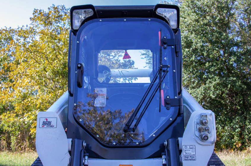 Bobcat M Series skid steer with forestry door and polycarbonate windshield installed, front view with wiper