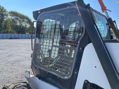 Bobcat M Series skid steer side cab view showing door, mesh guard, and OEM side window frame location