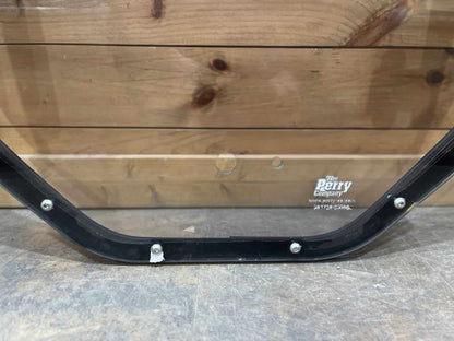 Bottom rail of Bobcat M Series steel windshield frame showing mounting bolts and The Perry Company manufacturer label