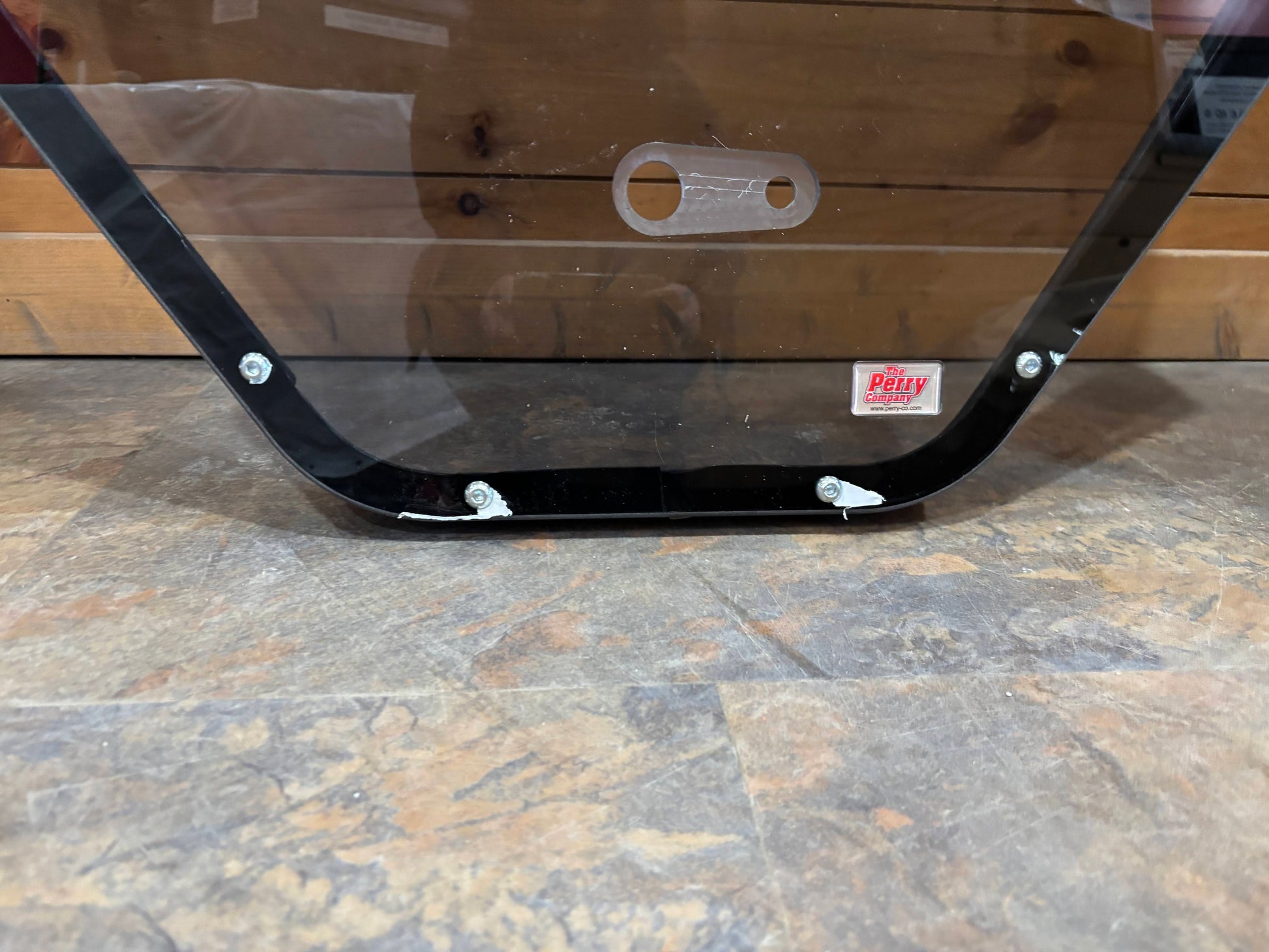 Bobcat R Series door frame bottom view showing curved lower frame rail, mounting hardware bolts, and product label