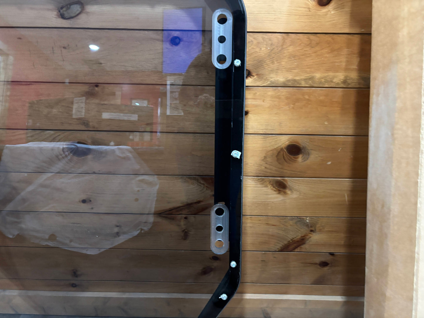 Bobcat R Series door frame right side panel close-up showing mounting adjustment slots and polycarbonate panel edge