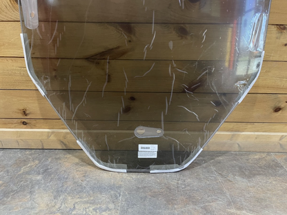 Close-up of Bobcat R Series polycarbonate windshield bottom corner showing rounded edge and product label
