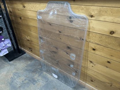 Case DL550 TV620B Minotaur polycarbonate windshield in protective wrap leaning against wooden wall