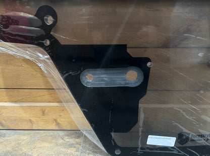 Close-up of Case/New Holland forestry door black wiper hinge bracket with mounting slots and Forestry Doors product label