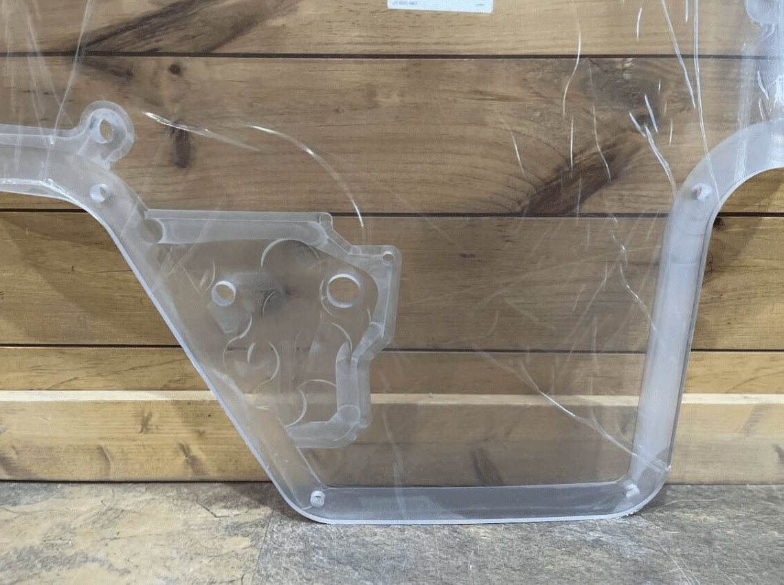 Bottom section of Case/New Holland polycarbonate forestry door showing wiper motor housing cutout and mounting holes