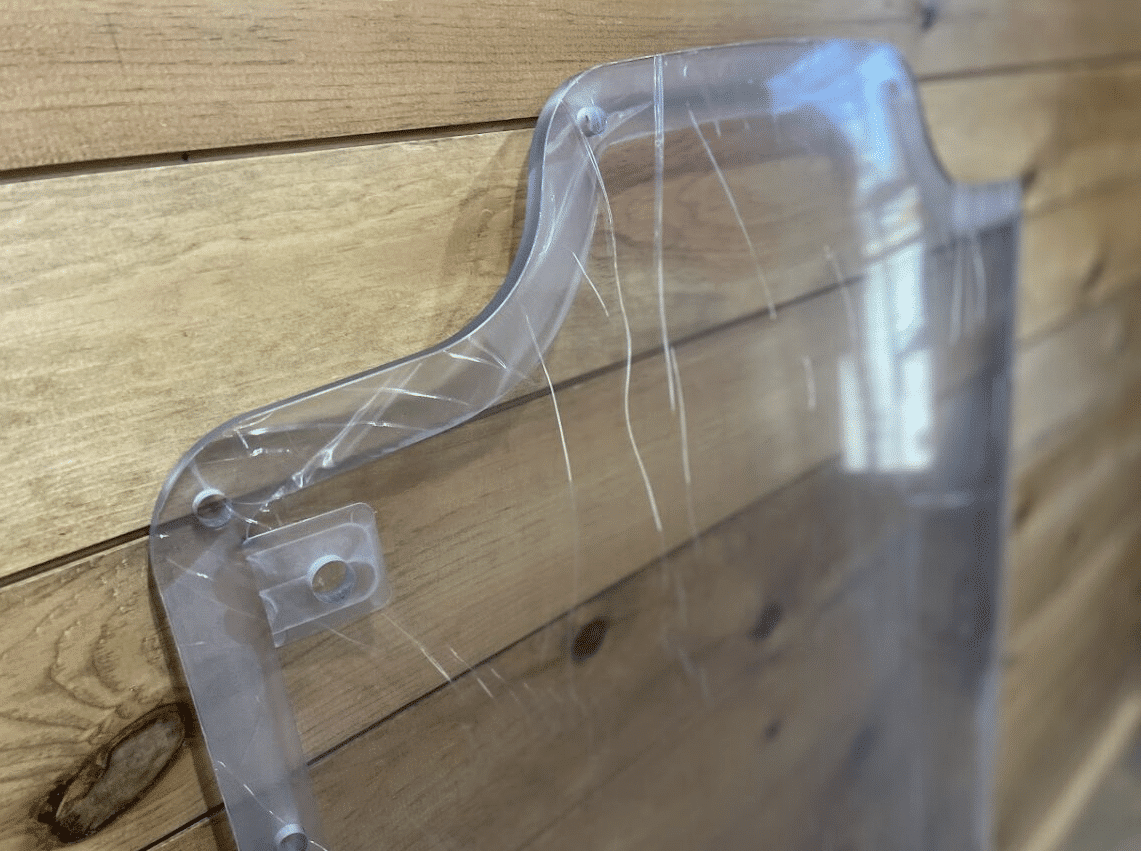 Top corner of Case/New Holland polycarbonate forestry door replacement showing bolt holes and milled frame edge