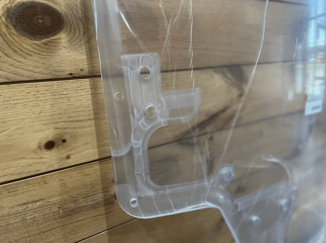 Detailed close-up of Case/New Holland forestry door polycarbonate wiper arm mounting bracket cutout and bolt holes