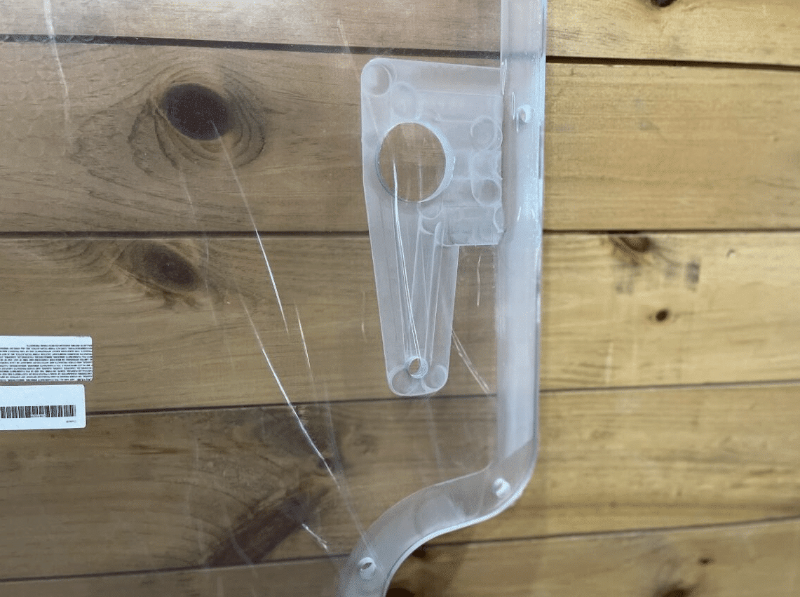 Close-up of Case/New Holland polycarbonate forestry door wiper motor mounting bracket and product label