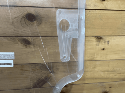 Close-up of Case/New Holland polycarbonate forestry door wiper motor mounting bracket and product label