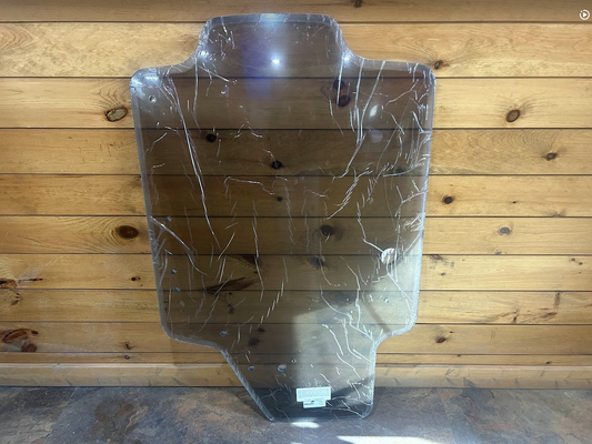 Case SR TR SV TV Series single arm polycarbonate windshield replacement panel, full front view with protective film on wooden wall