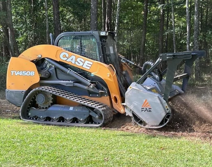 Case TV450B compact track loader with FAE stump grinder attachment working in a forested area