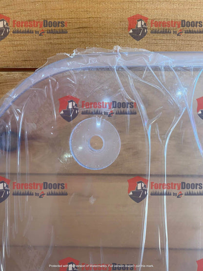 Close-up of Caterpillar C Series polycarbonate windshield top edge with milled OEM mounting hole detail
