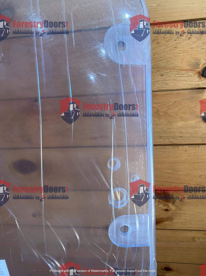 Top view of Caterpillar C Series polycarbonate windshield showing OEM mounting holes against wood background