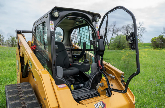 Caterpillar D Series skid steer loader with frame and windshield door open, outdoors in field