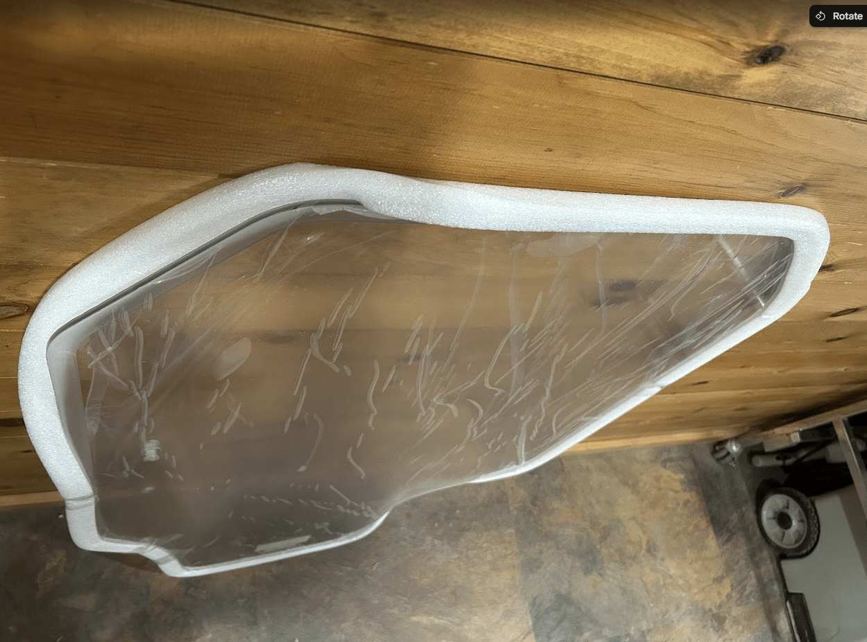 Top-down close-up of Gehl R and RT series polycarbonate windshield showing the upper edge and rubber seal