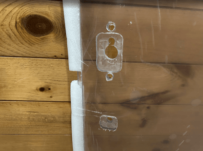 Close-up of Gehl R & V Series polycarbonate windshield showing milled OEM mounting bracket cutout detail