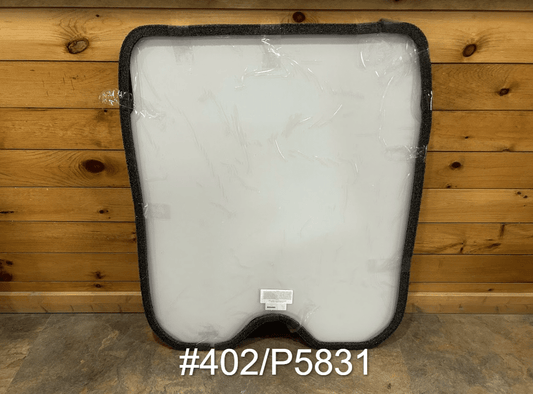 JCB #402/P5831 polycarbonate skid steer front windshield with rubber seal frame, shown in protective wrap against wooden wall