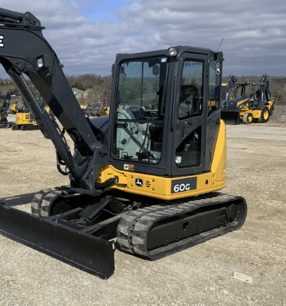 John Deere 60G mini excavator with polycarbonate windshield installed, photographed outdoors on a job site