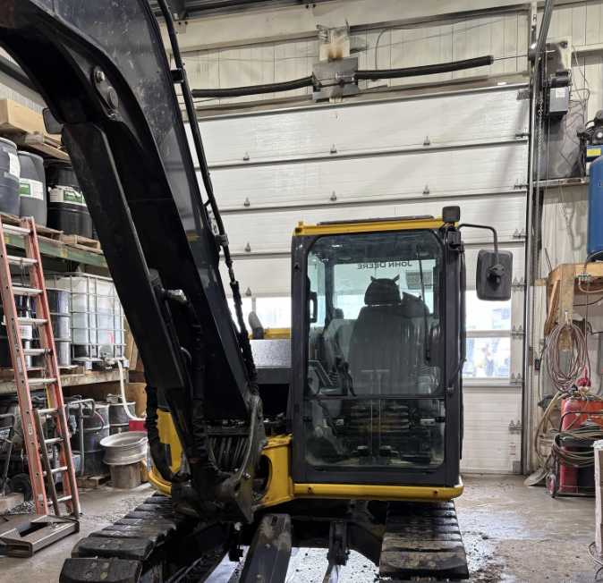 John Deere 75P 85P excavator with polycarbonate windshield installed, front cab view in a workshop