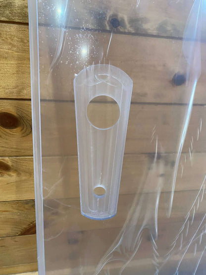 Close-up of hinge tab detail on John Deere D Series polycarbonate windshield showing hinge hole cutouts