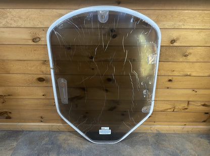 John Deere G Series small frame tinted polycarbonate windshield in protective plastic wrap against wooden background