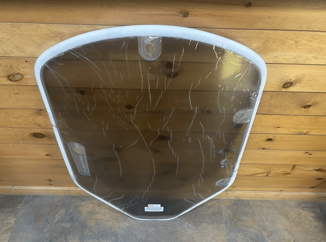John Deere G Series small frame tinted polycarbonate windshield top-down view showing shape and mounting tabs