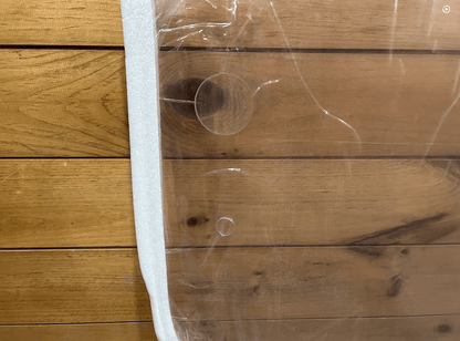 Close-up of upper corner of John Deere G Series small frame polycarbonate windshield with foam edge protector and mounting hole