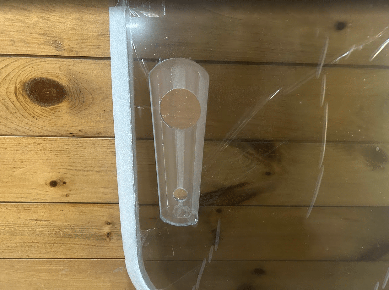 Close-up of the side latch handle on John Deere G Series small frame polycarbonate windshield showing mounting hole