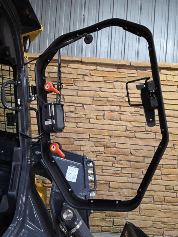 John Deere P Series skid steer cab door opening showing latch hardware before windshield installation