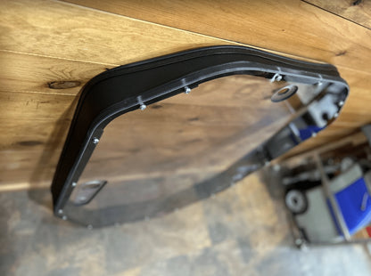 Close-up of upper corner of John Deere P Series windshield frame showing metal construction and rubber seal
