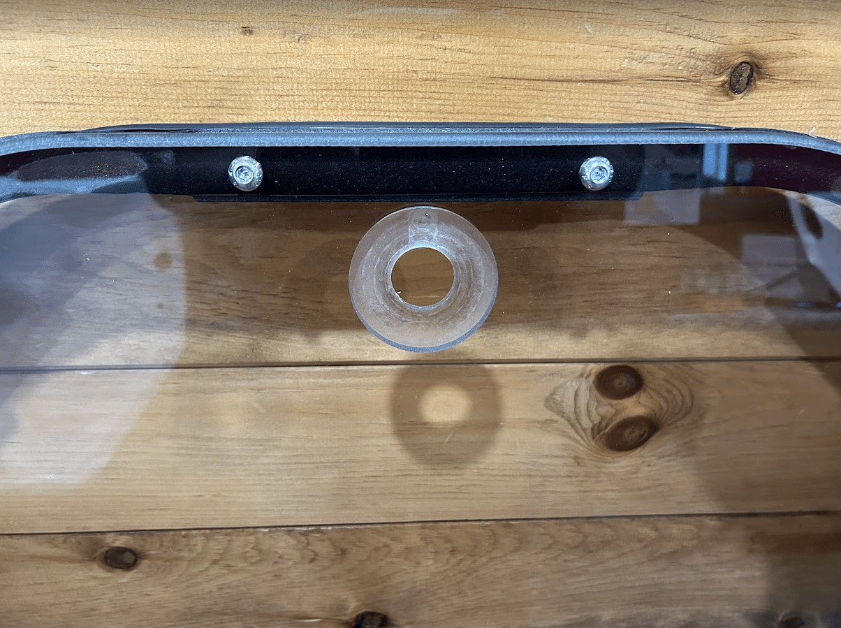 Close-up of top center of John Deere P Series windshield frame showing mounting grommet and frame bolts