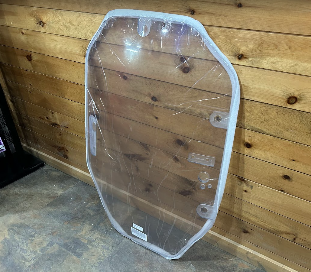 John Deere P Series windshield with white frame shown at slight angle, protective film on, mounting brackets visible on right side